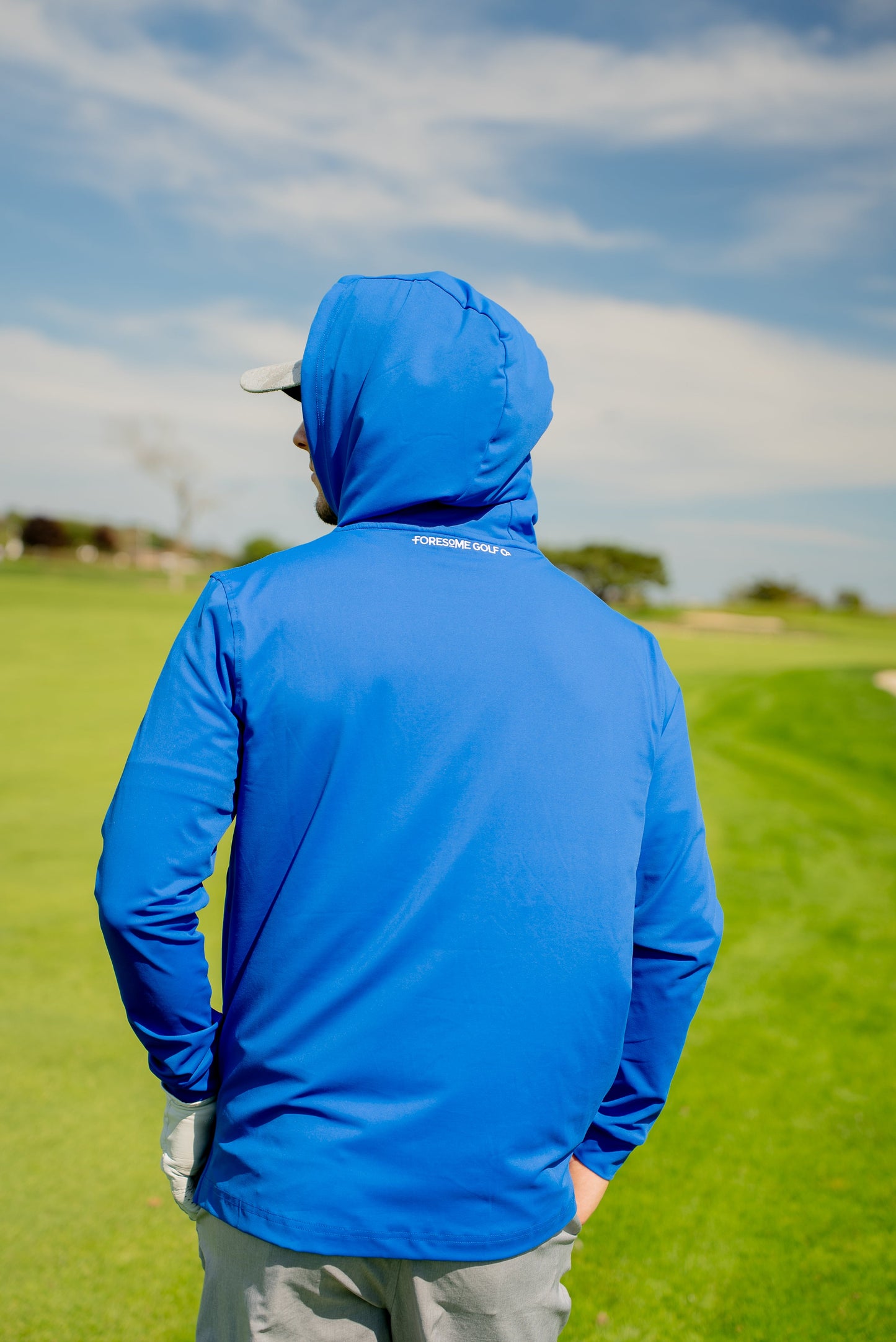 Rear shot of men’s royal blue hoodie showing athletic cut, clean design lines, and casual fit for all-day wear on or off the course.