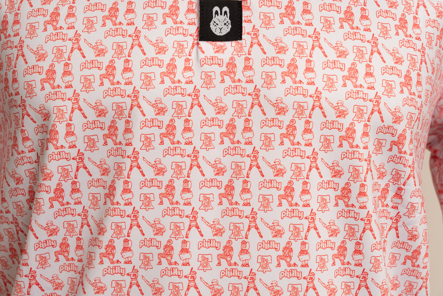 Close-up front view of The South Philly Sandlot golf polo highlighting red and white Philadelphia baseball-inspired design and premium performance fabric